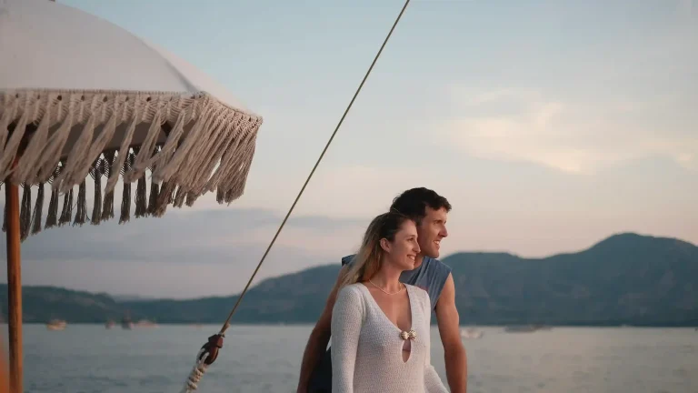 Couple on the deck of a phinisi during a Komodo honeymoon cruise at golden hour