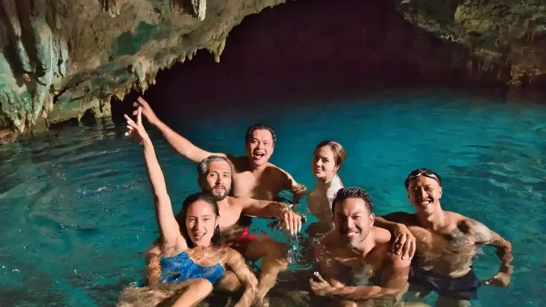 Sunlight falling through the roof of Rangko Cave onto a turquoise saltwater pool near Labuan Bajo